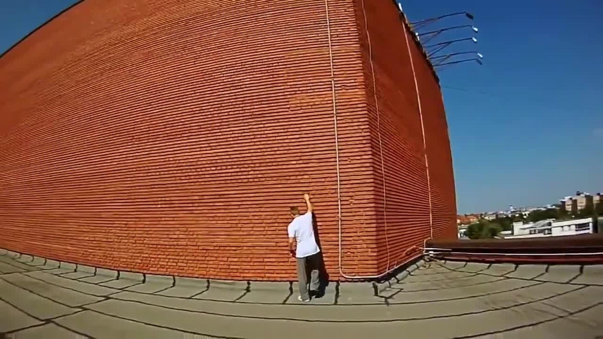 Man Climbs Up Brick Building
