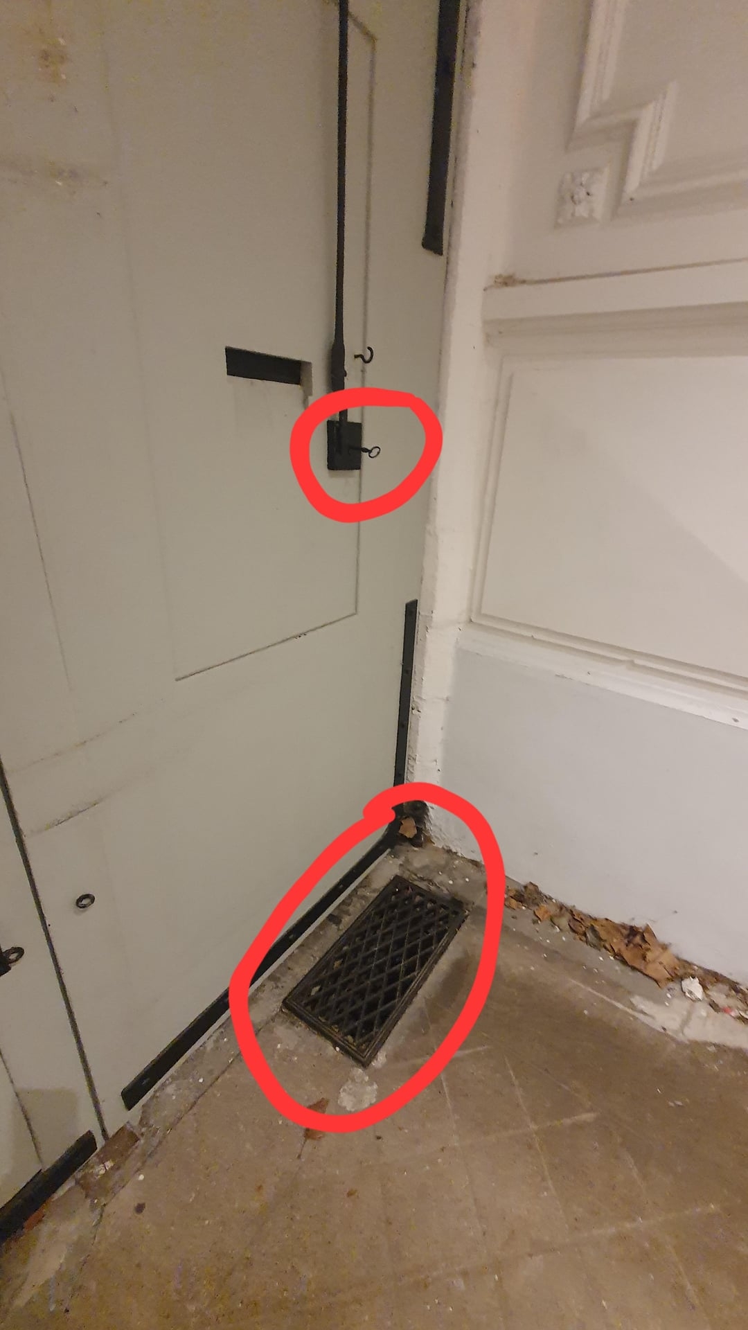 Door with a latch system and floor vent circled. Potential DIY project or home improvement focus
