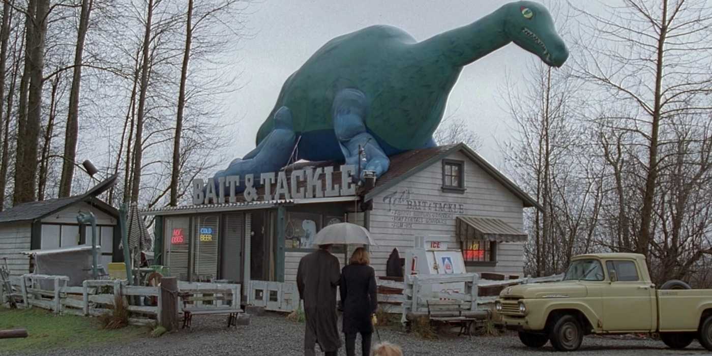 Mulder and Scully visit a bait and tackle shop with a blow-up sea monster on its roof in The X-Files Quagmire