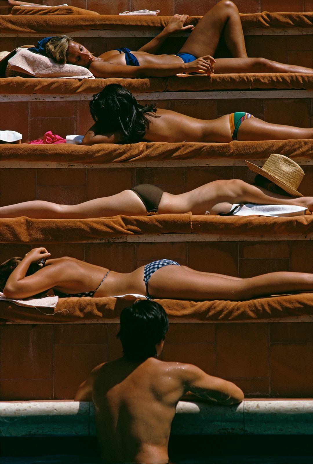 Sunbathers by a hotel swimming pool in Italy, 1974