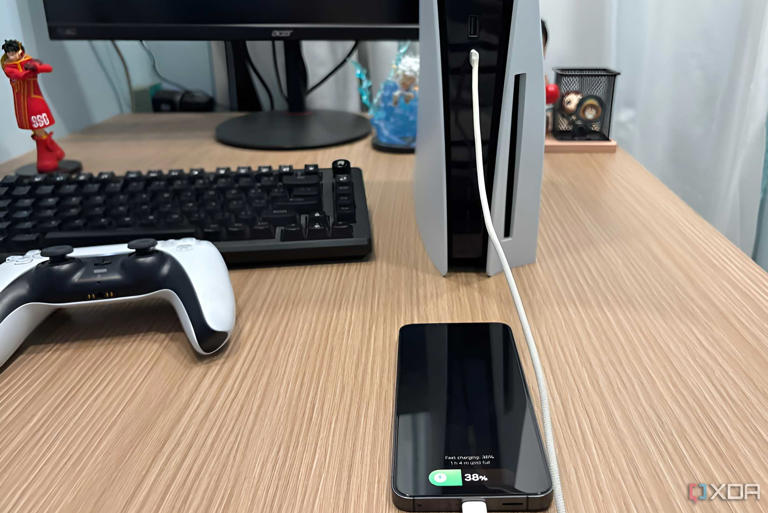 An iPhone charging from the front USB-C port of the PlayStation 5.