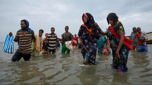 FILE - In this July 26, 2019, file photo, Ethiopian migrants disembark from a boat onto the shores of Ras al-Ara, Lahj, Yemen