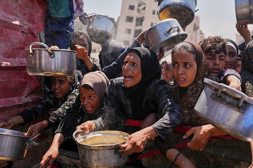 Palestinians struggle to get donated food at a community kitchen in Gaza City, 4 August, 2025 AP Photo