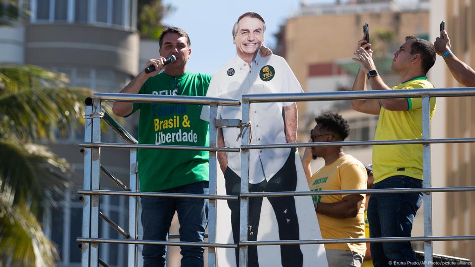 Senador Flávio Bolsonaro discursa em Copacabana neste domingo segurando cartaz que representa Jair Bolsonaro