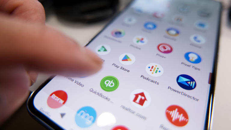 Finger about to click on Google Play app on Android phone.