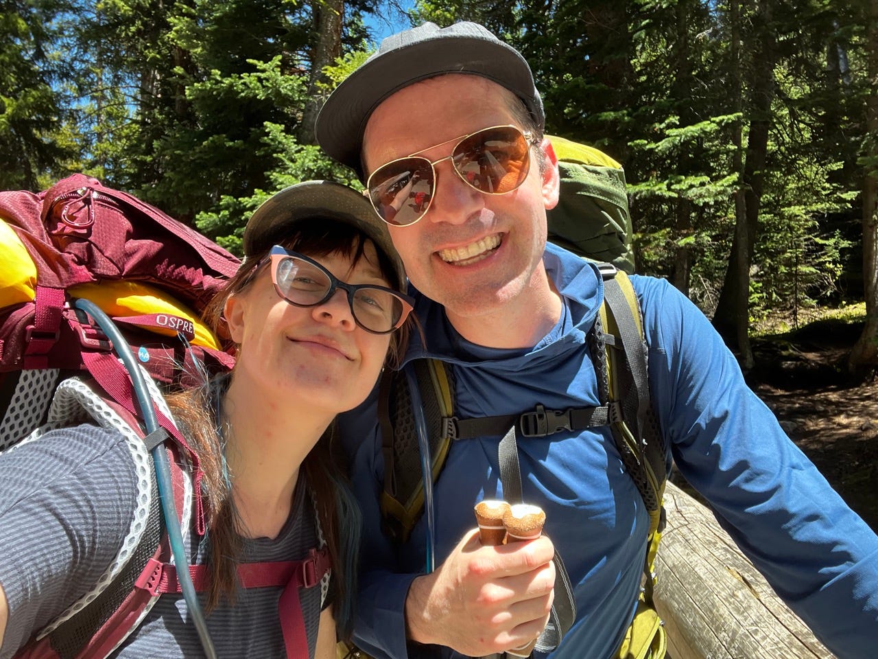 Author Emily Pennington and partner wearing hiking backpacks on trail