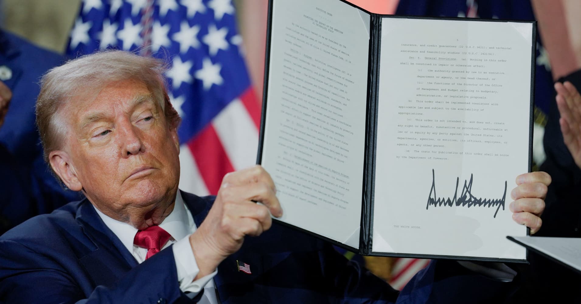 U.S. President Donald Trump holds an executive order related to AI after signing it during the