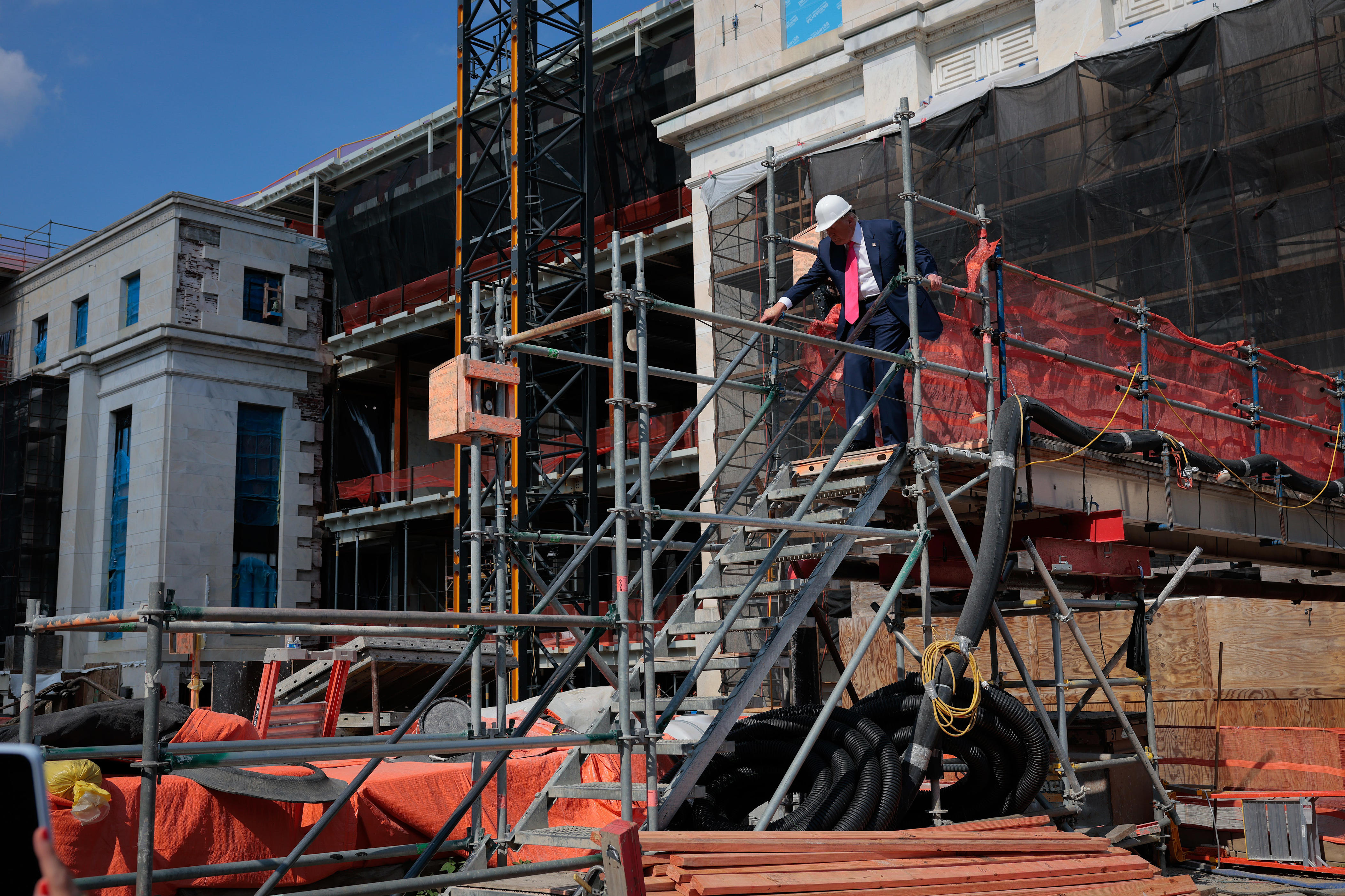 President Donald Trump descends a set of stairs as he tour the Federal ReserveÕs $2.5 billion headquarters renovation project on July 24, 2025 in Washington, DC. The Trump administration has been critical of the cost of the renovation and Federal Reserve Chairman Jerome Powell.