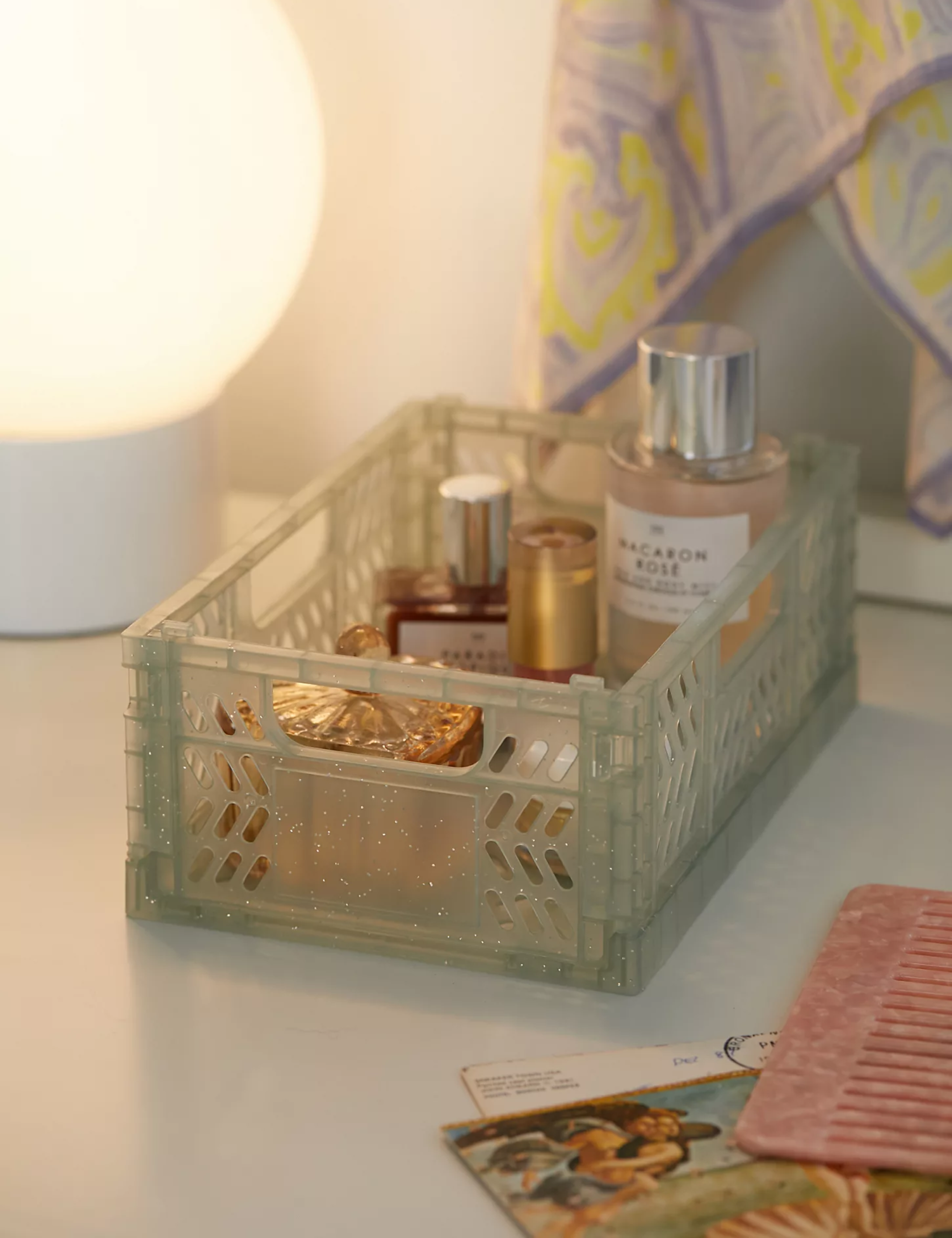 Catchall crate on desk holding perdume bottles, jewlery, and combs