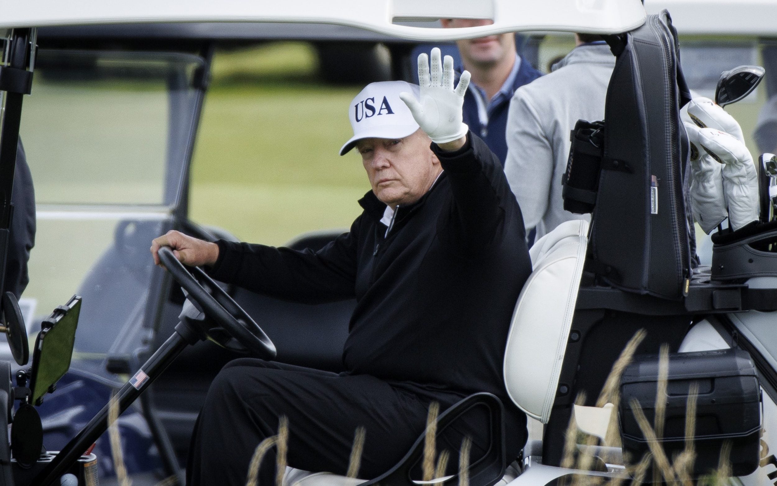 President Donald J. Trump waves as he plays at Trump Turnberry golf course