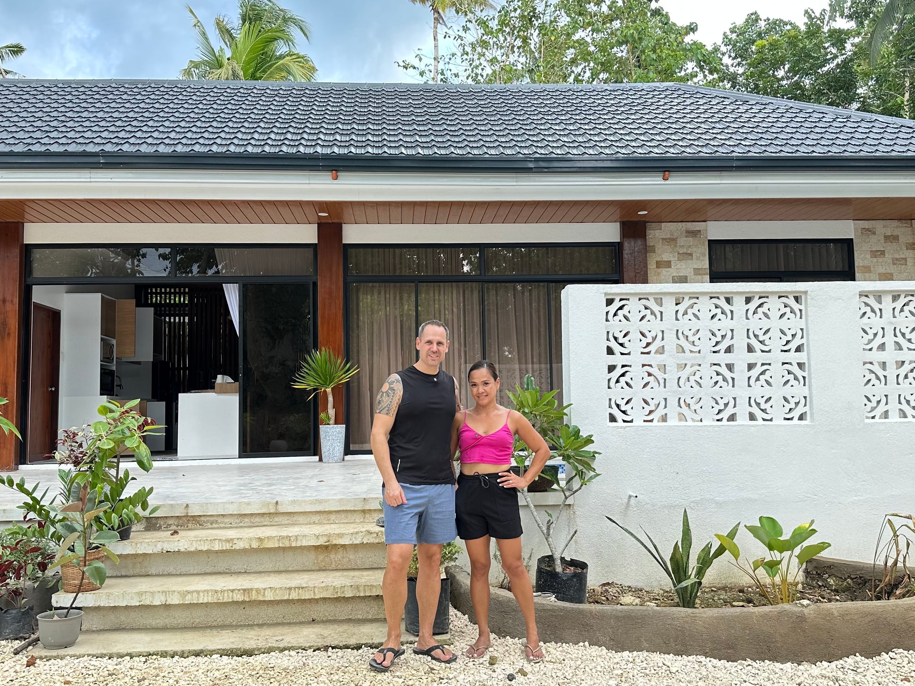 A couple standing in front of a house in Bohol, in the Philippines.