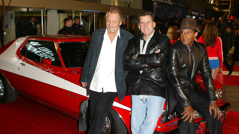 Actors David Soul, Paul Michael Glaser, and Antonio Fargas from the TV series 'Starsky & Hutch' pose on the bonnet of a Ford Torino at the premiere of the 2004 movie remake.