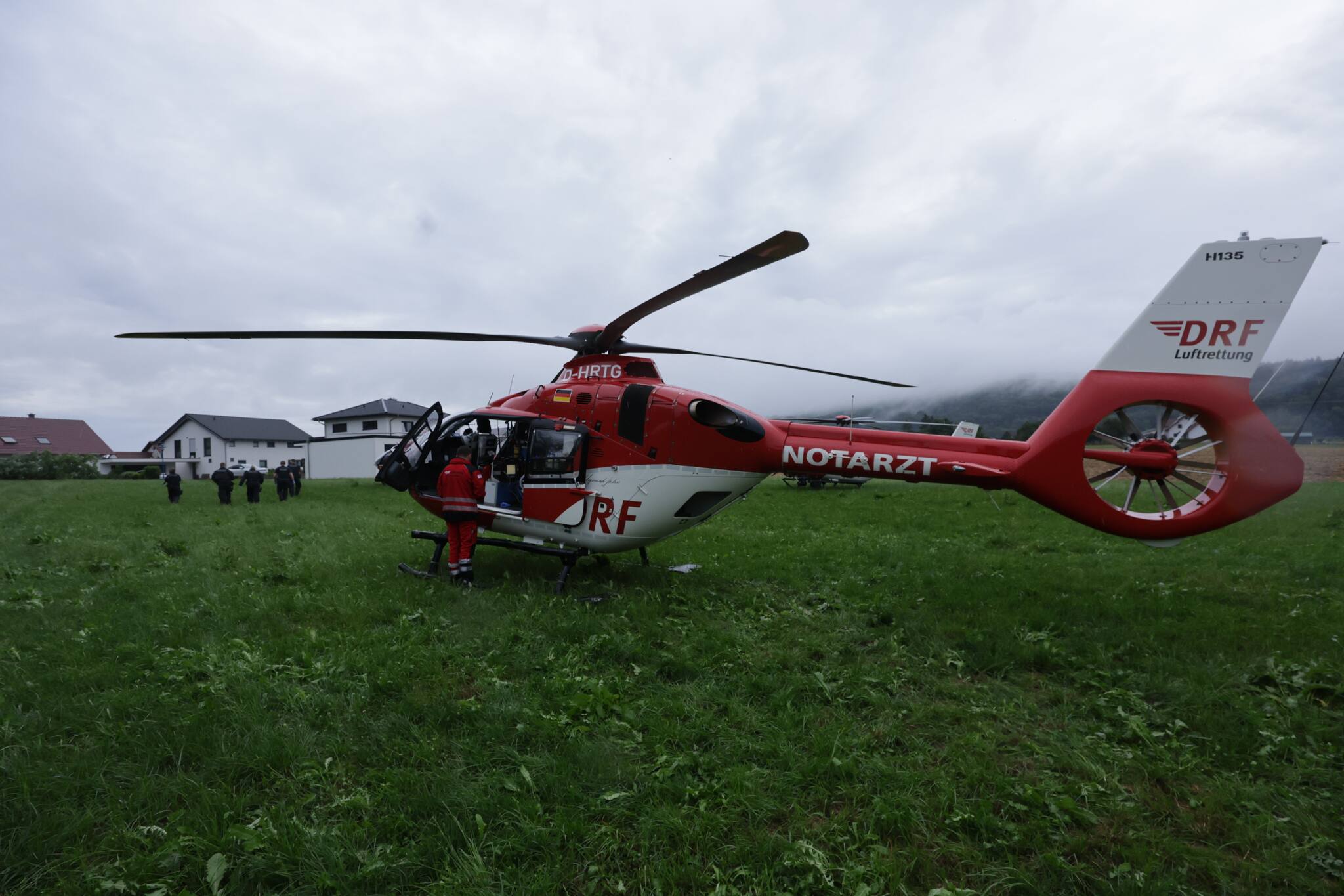 Ein Notarzt-Hubschrauber der DRF Luftrettung steht auf einem Feld nahe des Bahnunglücks. Quelle: Thomas Warnack/dpa