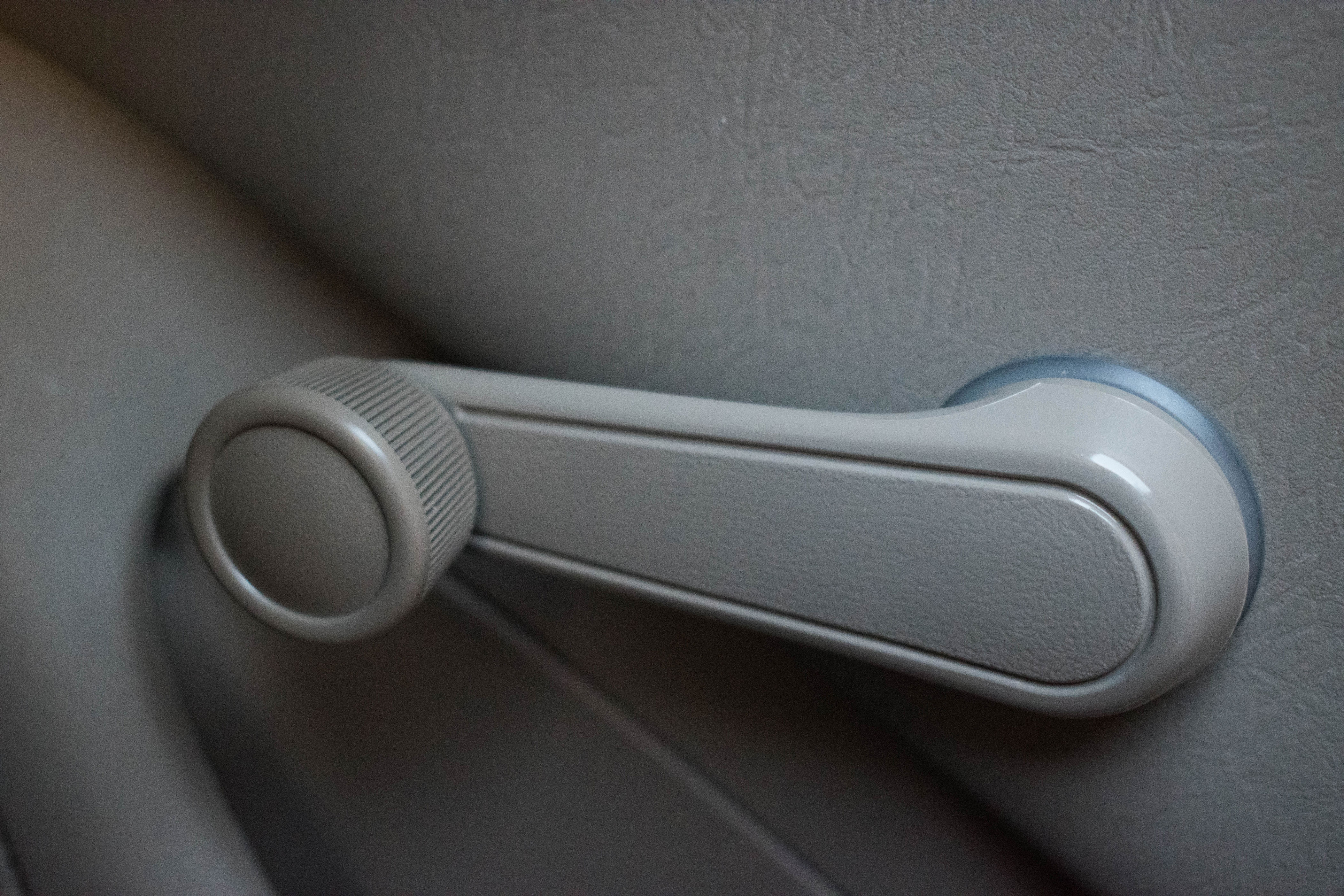 Manual car window crank handle on a vehicle door panel