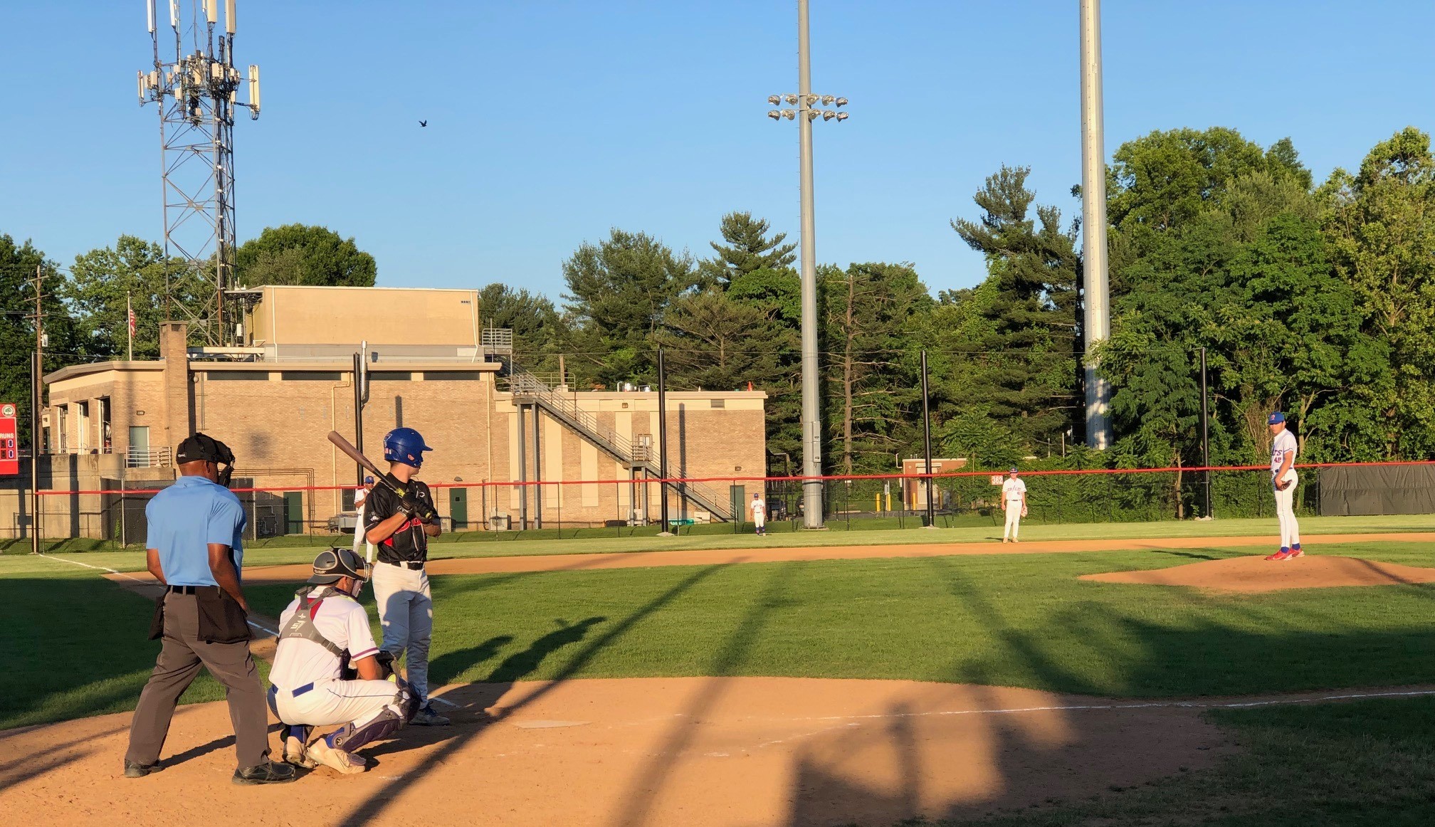 The fire station sits behind left field, just beyond the tall net fence.