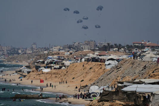 Humanitarian aid is air-dropped to Palestinians (Abdel Kareem Hana/AP)