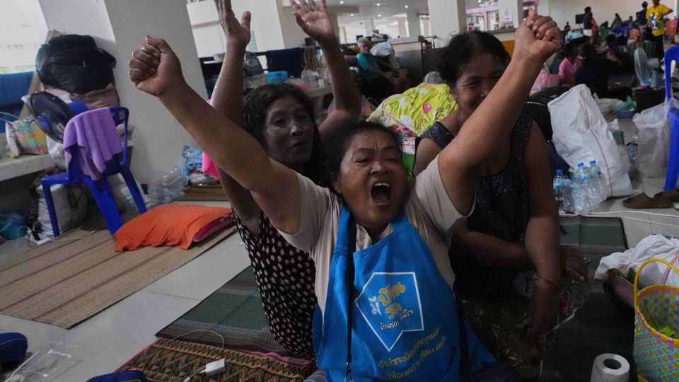 Thai residents who fled their homes following the cross-border clashes celebrate at an evacuation center in Surin province, Thailand, after hearing the announcement of an immediate and unconditional ceasefire on Monday. - Sakchai Lalit/AP