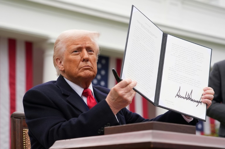 Le président américain Donald Trump brandit un décret sur les droits de douane, le 2 avril 2025 à la Maison Blanche, à Washington