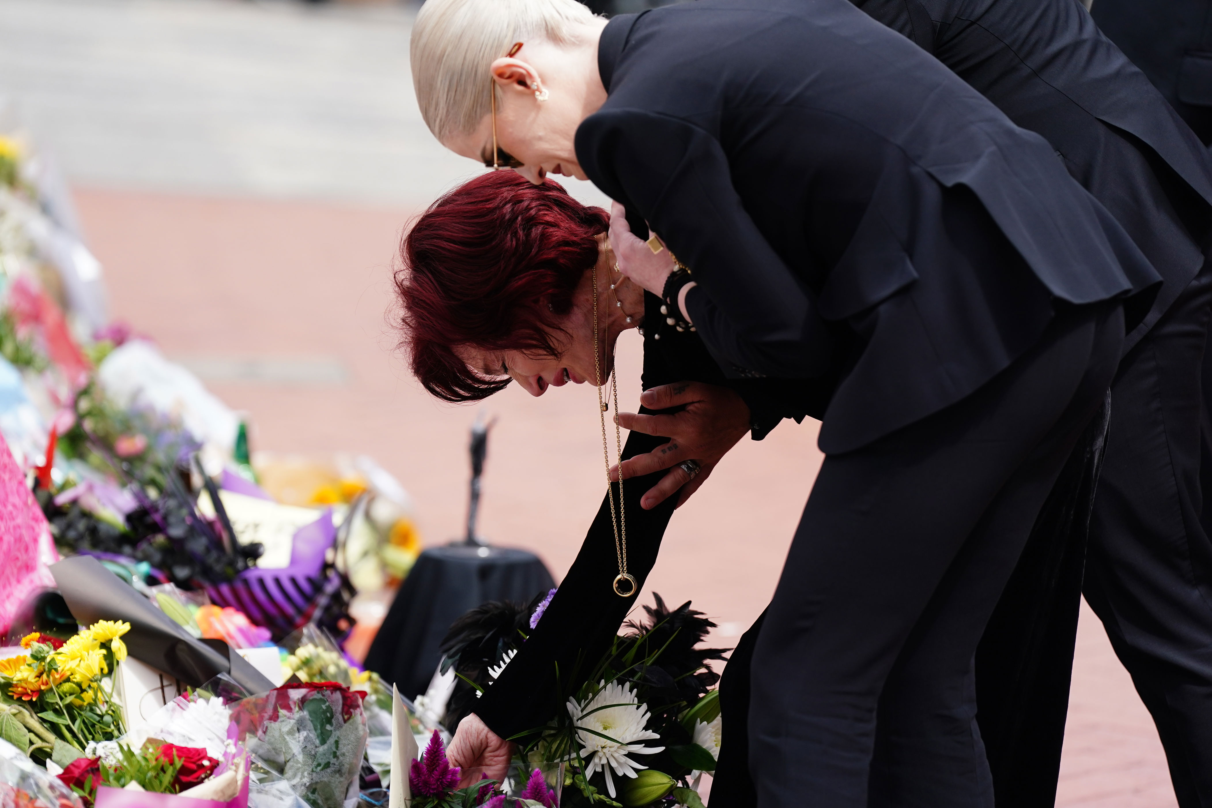 Sharon and Kelly Osbourne lay flowers at the Black Sabbath Bridge bench (Joe Giddens/PA) (PA Wire)