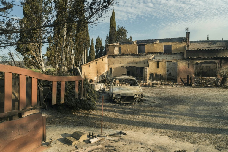 Une voiture brûlée devant les décombres d'une maison ravagée par les flammes, le 6 août 2025 à Saint-Laurent-de-la-Cabrerisse, dans l'Aude