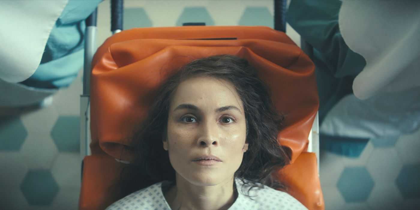 Jo (actor Noomi Rapace) lays on a red coat staring up at the viewer in Apple's Constellation