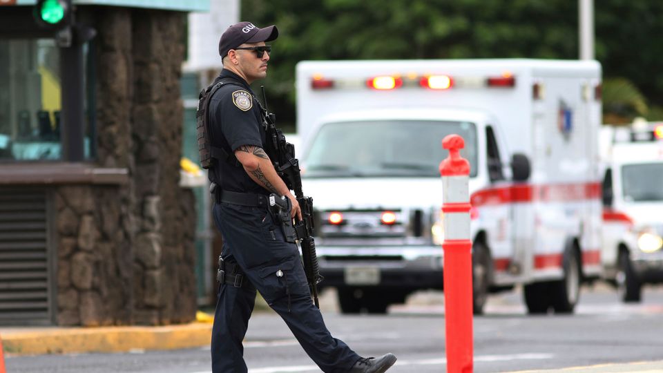 A security guard stands outside the main gate at Joint Base Pearl Harbor-Hickam, in Hawaii on December 4, 2019. - Caleb Jones/AP