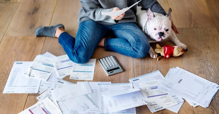 Woman and dog on floor with papers and calculator