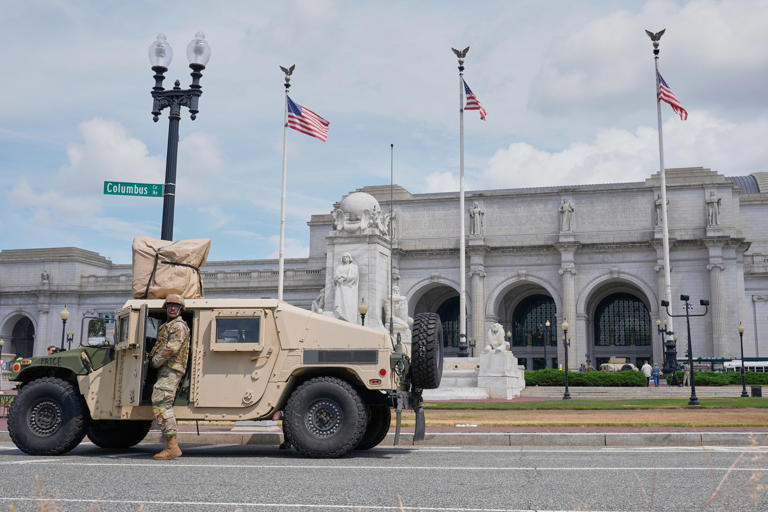 District of Columbia National Guard soldiers keep watch as travelers arrive at Union Station near the Capitol, Thursday, Aug 14, 2025, in Washington. (AP Photo/Mariam Zuhaib)