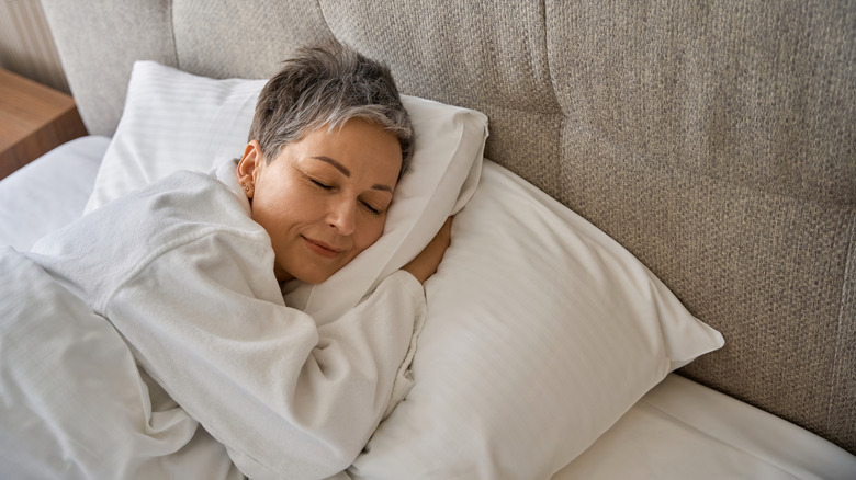 a woman sleeping in a comfortable bed