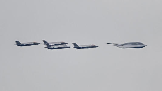 F-35 jets and a B-2 bomber accompany the plane carrying the Russian President Vladimir Putin as he arrives at Elmendorf-Richardson Joint Base ahead of Russian President Vladimir Putin and US President Donald Trump meeting in Alaska, United States on August 15, 2025. - Fatih Aktas/Anadolu/Getty Images