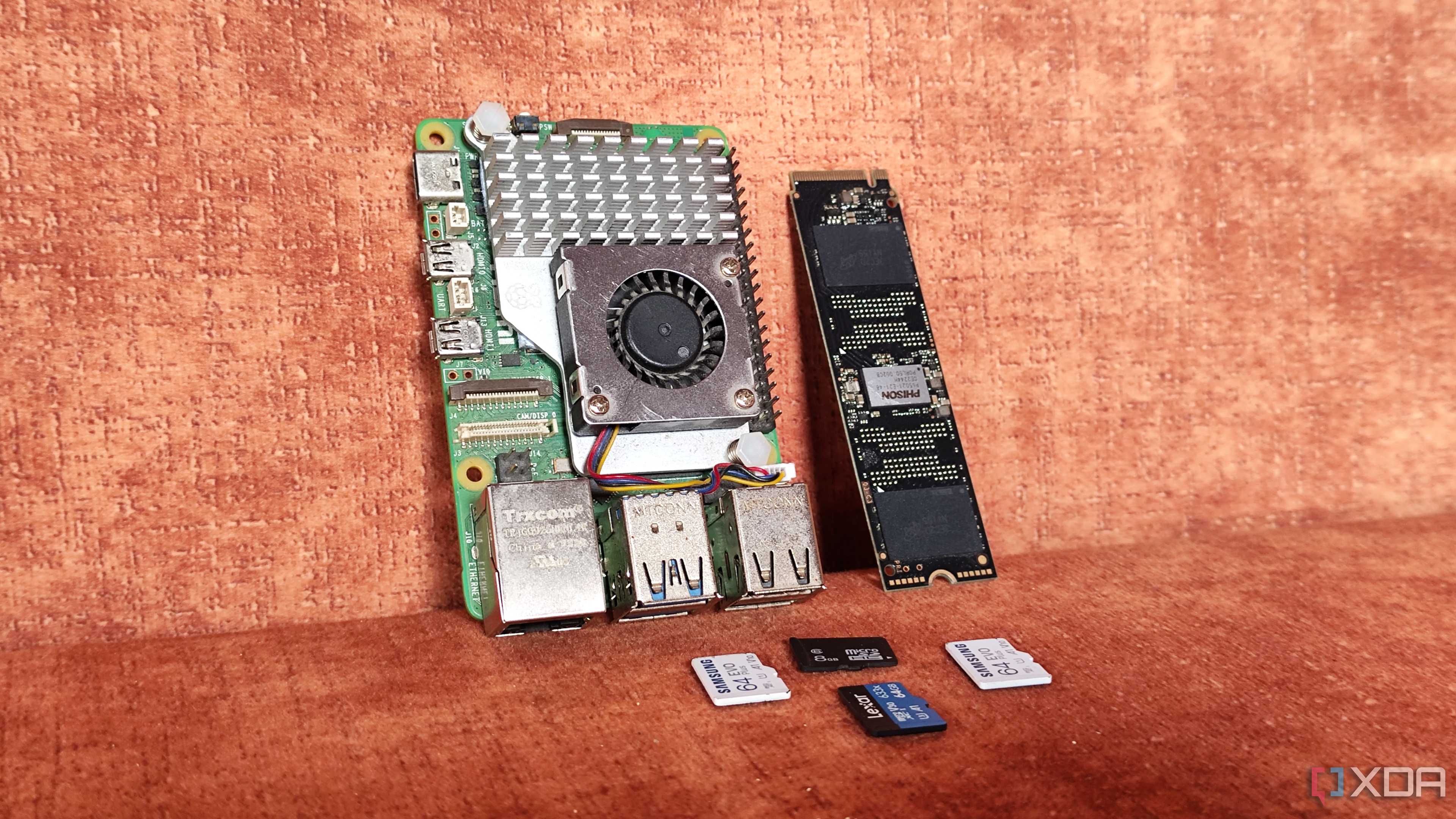 A Raspberry Pi lying next to an SSD and some microSD cards