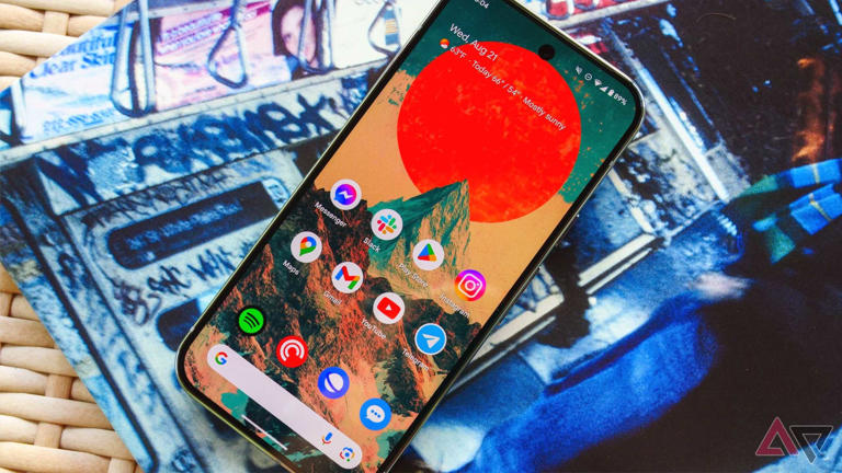 The Pixel 9 Pro on a wicker table and lying on top of an album sleeve with the display up
