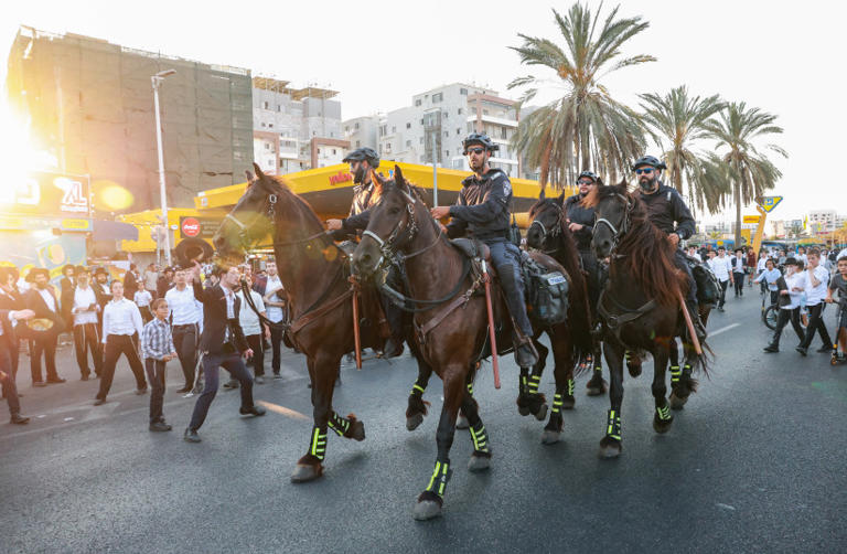 Ultra-Orthodox Jewish men block a road and clash with police outside Bnei Brak, during a protest against the arrest of three yeshiva students for refusing to enlist in the Israeli military, July 23, 2025. (credit: David Cohen/Flash90)