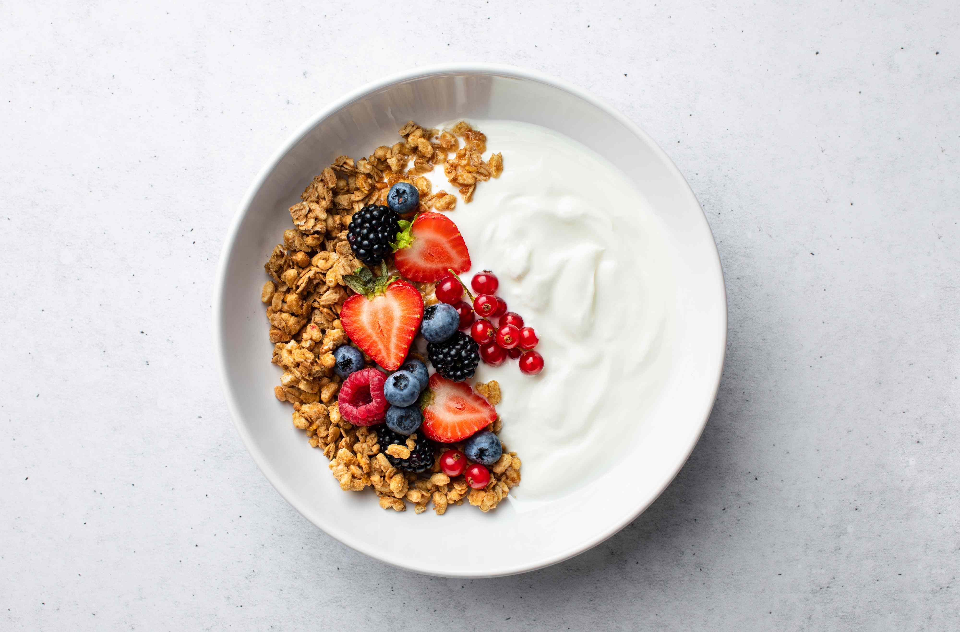 best time to eat yogurt; Granola with yogurt and fresh berries, top down view