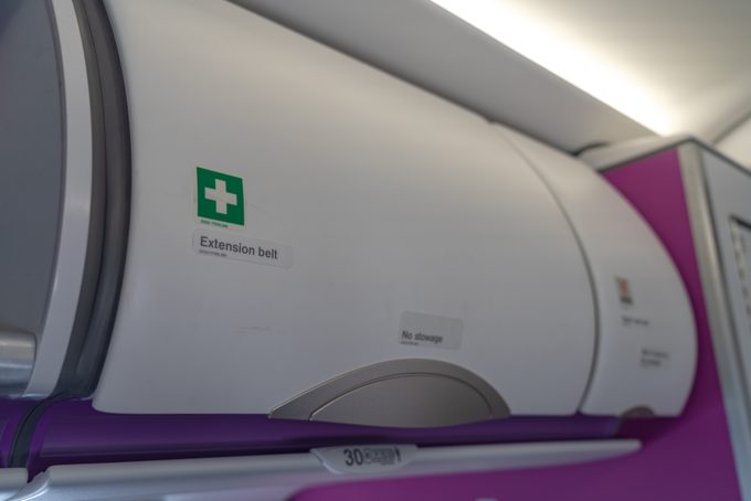 Medical Carry-on luggage in overhead storage compartment on commercial airplane