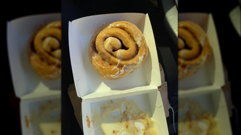 A sad-looking cinnamon roll in a cardboard box
