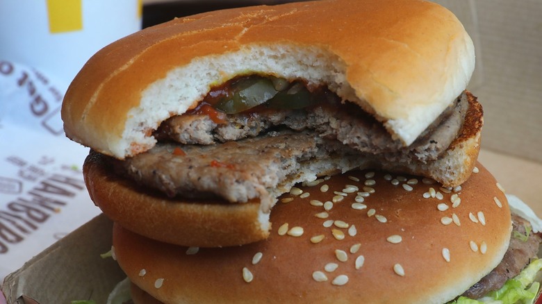 A McDonald's double hamburger with a bite taken out sits on top of another burger