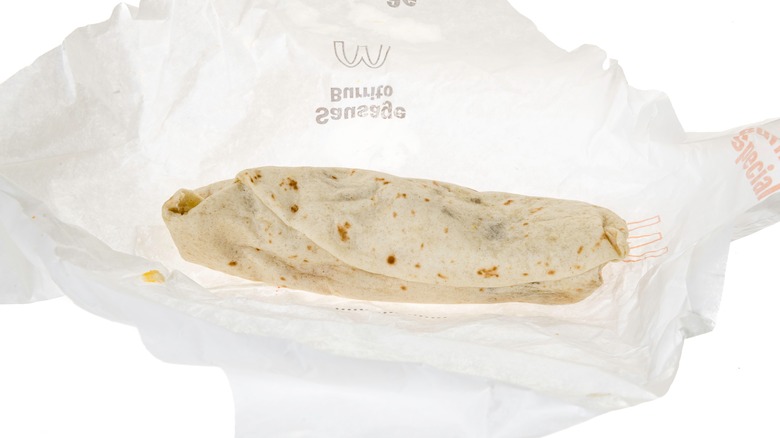 A burrito on Mcdonald's branded paper isolated on a white background