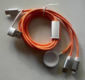 Multi-connector charging cable with USB, USB-C, Lightning, and Micro-USB ends, coiled in a compact design. Ideal for versatile device charging