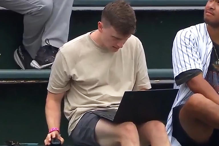 MLB/Twitter Chicago Cubs fan works from outfield bleachers during Tuesday's game against the Milwaukee Brewers