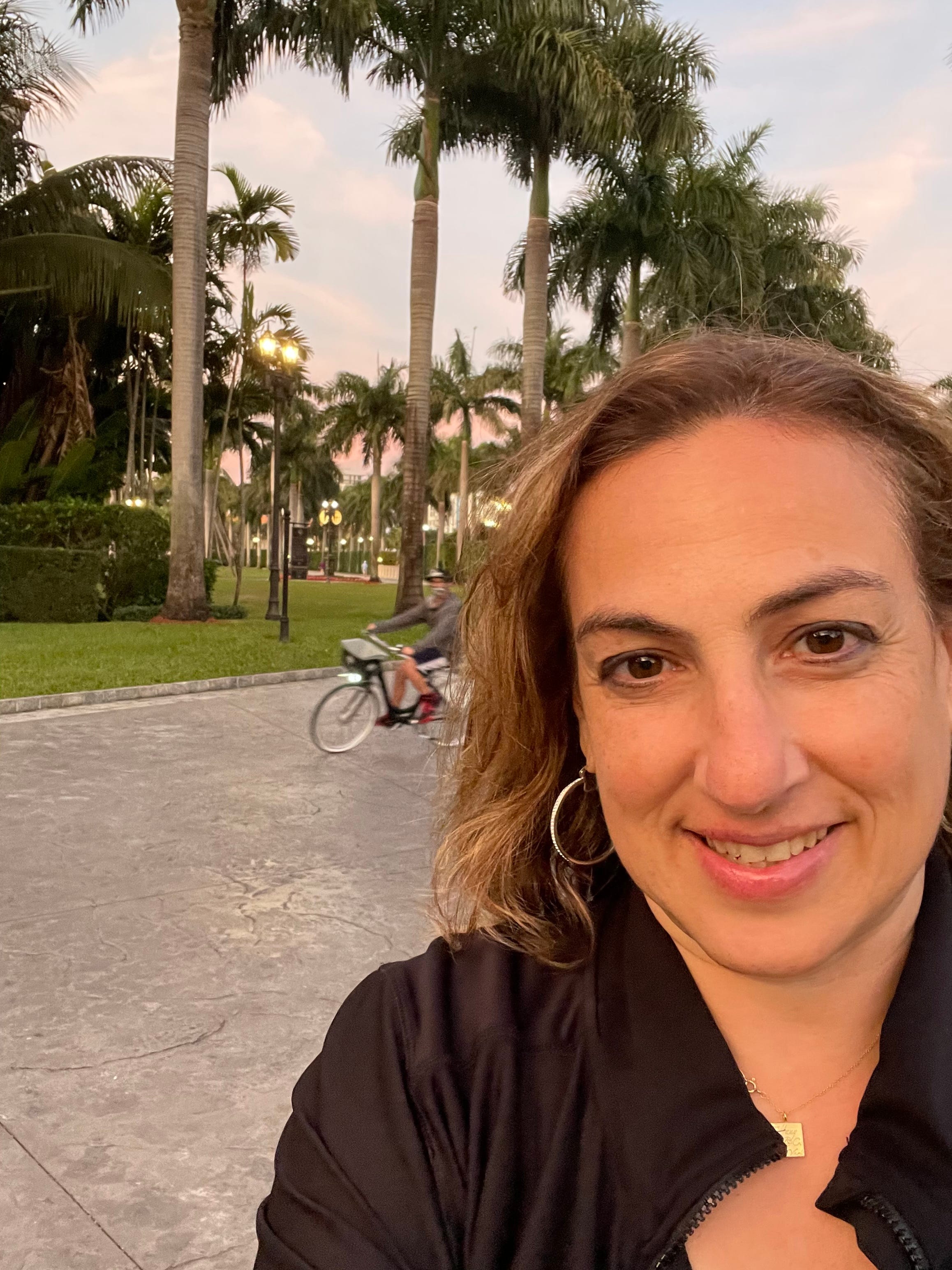 selfie of Esther Fink with palm tree in background