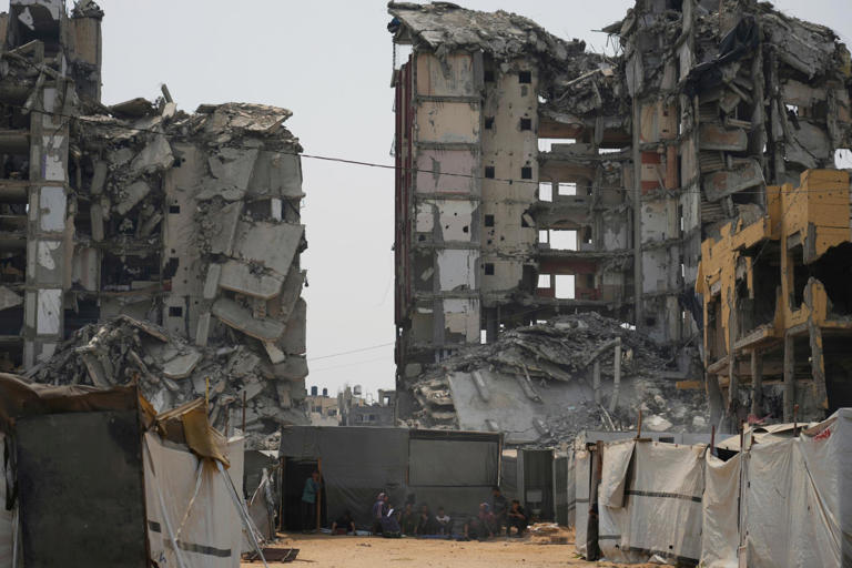 Palestinians sit in the shade of their tent amid destroyed buildings in Gaza City on Tuesday. Photograph: Jehad Alshrafi/AP