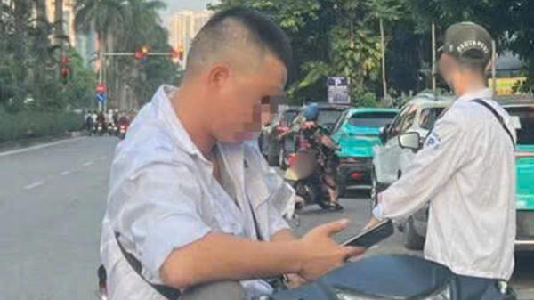 Hình ảnh người đàn ông chặn xe giữa đường đòi tiền trông giữ. Ảnh: Minh Phương
