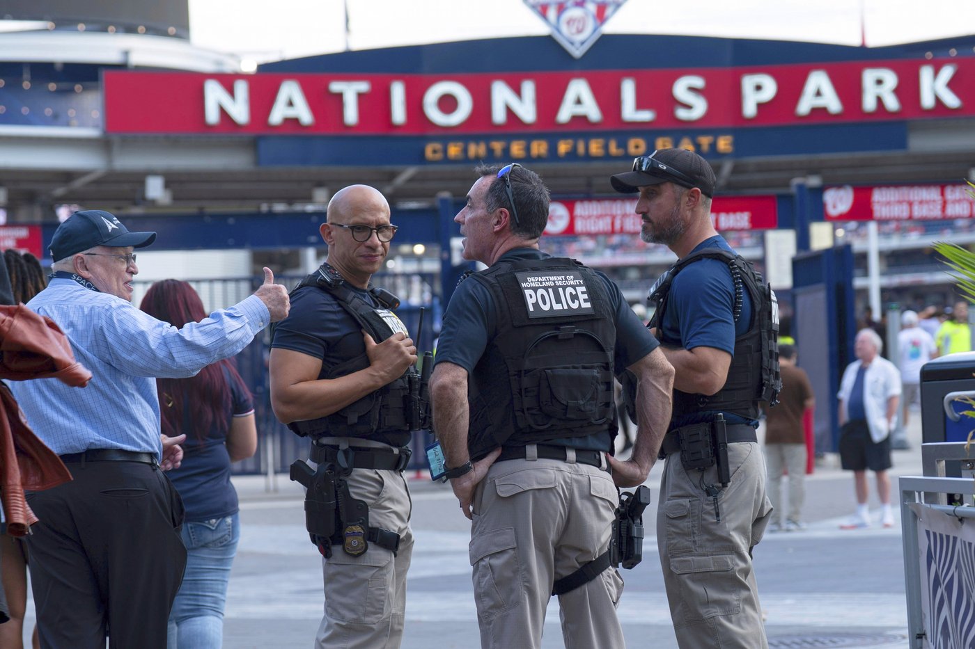 Department of Homeland Security police officers interact with people arriving at Nationals Park during a baseball game between the Washington Nationals and Philadelphia Phillies in Washington, Thursday, Aug. 14, 2025. (AP Photo/Jose Luis Magana)