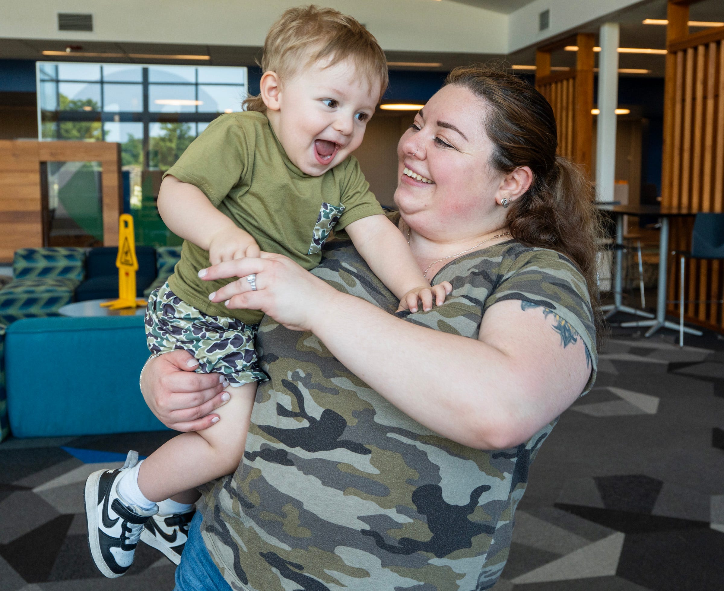Alyson Koerts Meijer laughs with her 19-month-old son Grayson on Aug. 8, before settling down to do homework in the student center at Mount Wachusett Community College in Gardner, Mass.