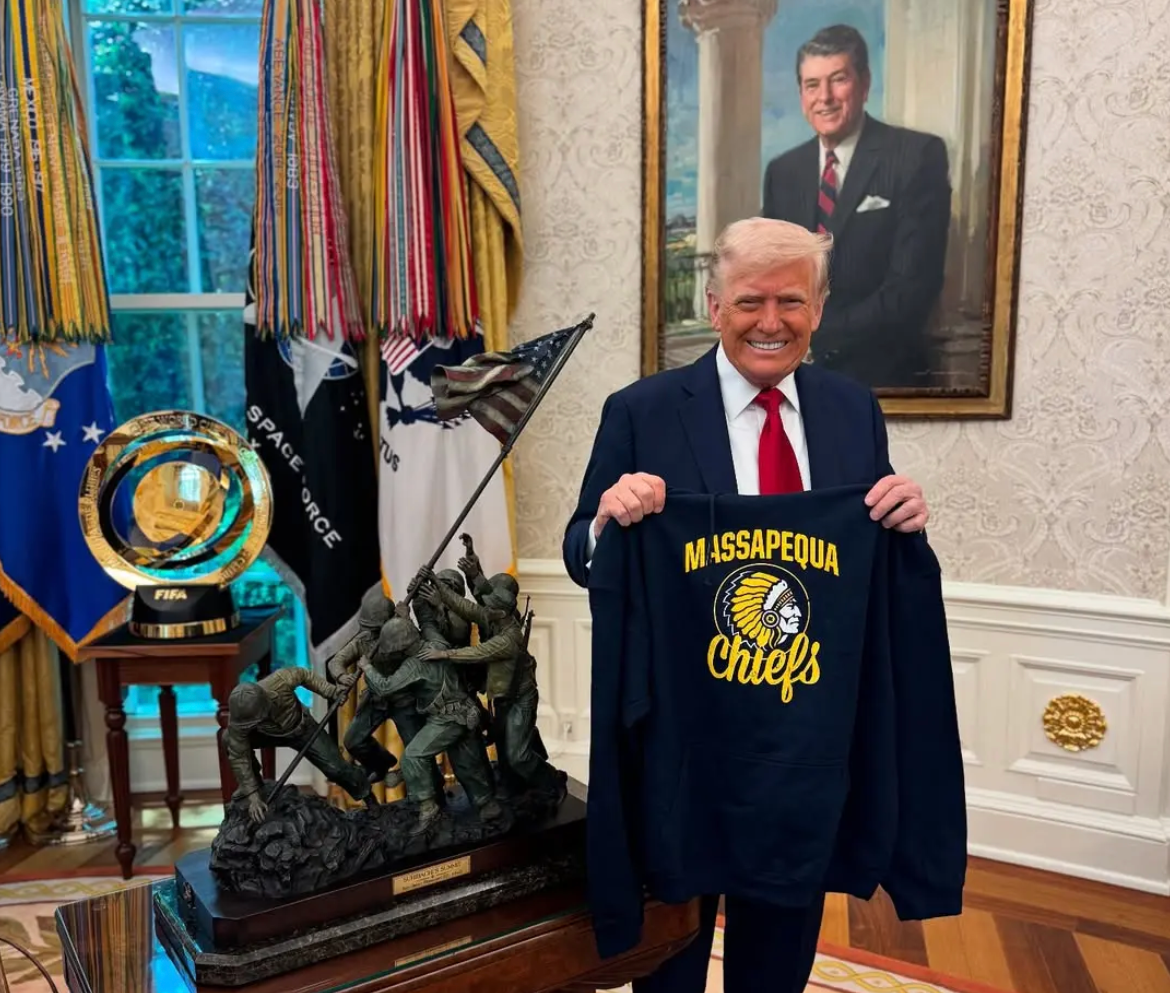 President Donald Trump poses with a Massapequa Chiefs jersey in the Oval Office of the White House in April to express his support for the school (realdonaldtrump/Instagram)