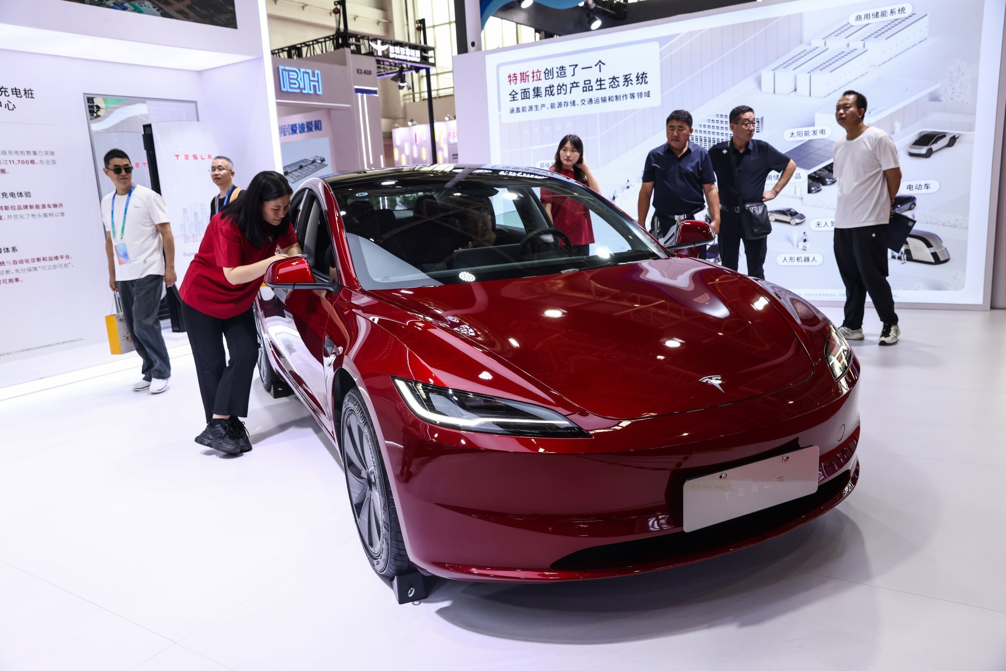 Visitors check out a Tesla electric vehicle on display at the third China International Supply Chain Expo in Beijing on July 16, 2025. Photo: EPA