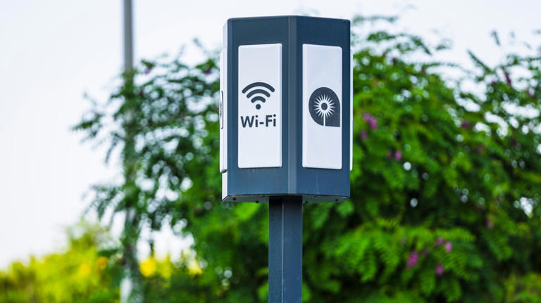 Public Wi-Fi access point on a metal pole in a green park setting