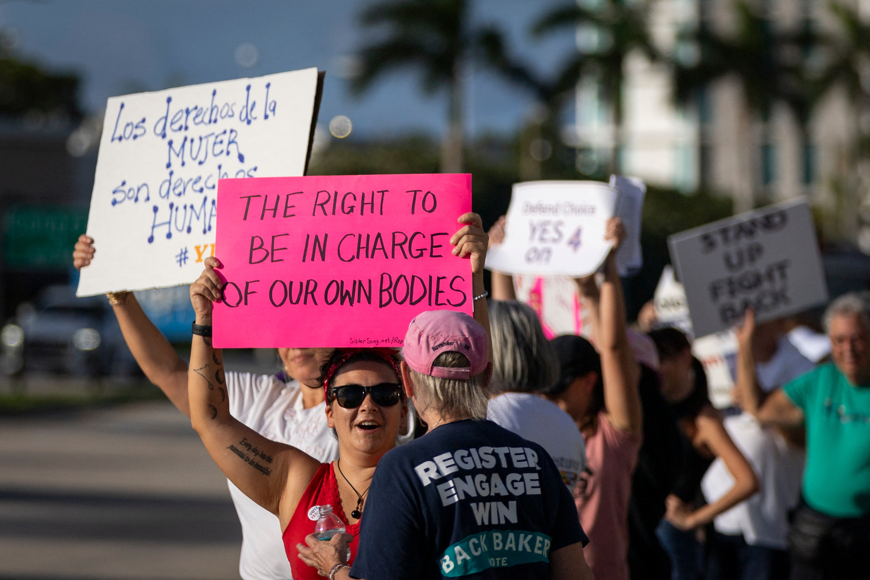 Protesters holding signs about women's rights, including one reading