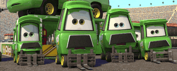 Four animated forklift characters with expressive eyes from the "Cars" movie series are gathered in a stadium setting, appearing curious and alert